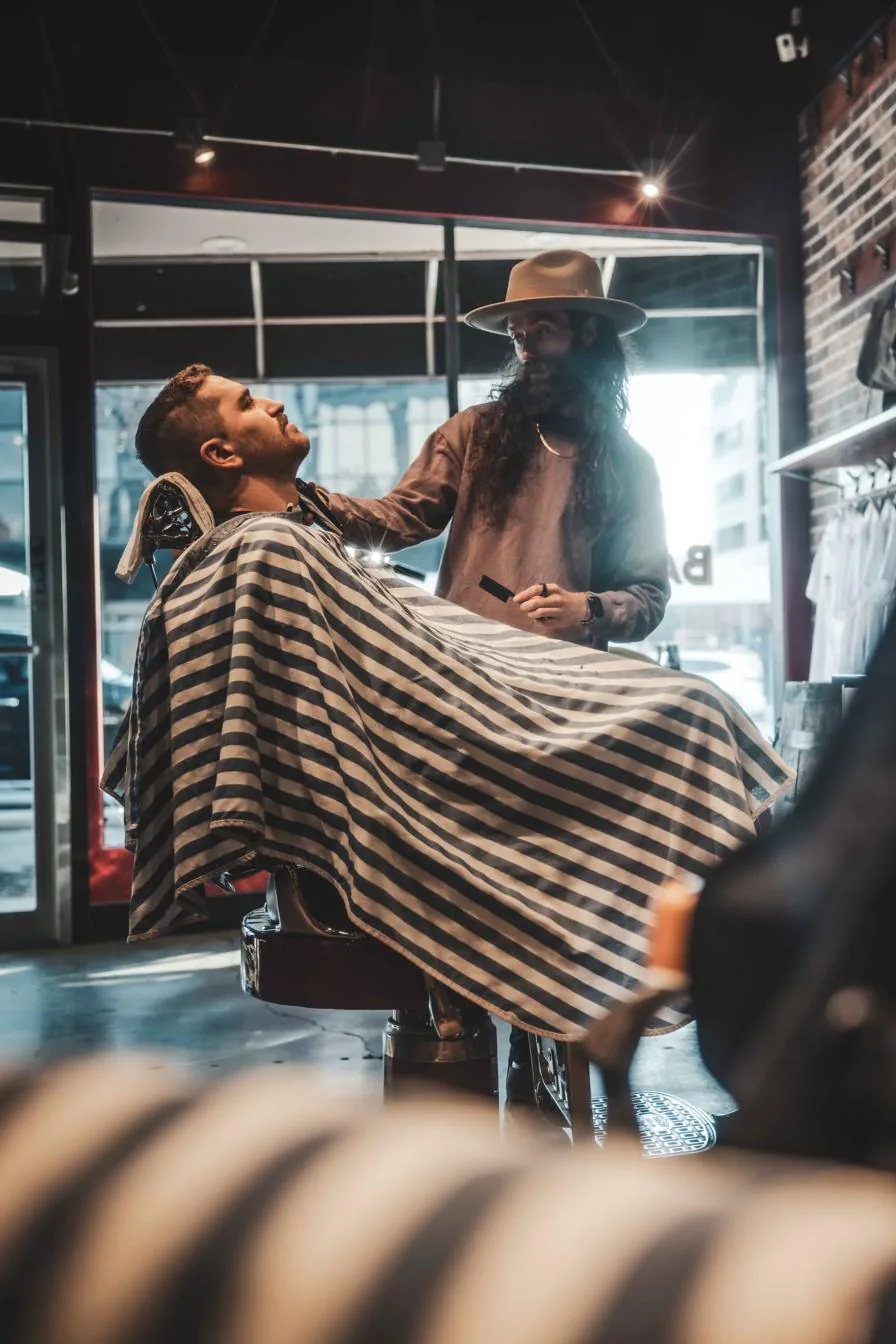 A City Barbers barber at work by the front window