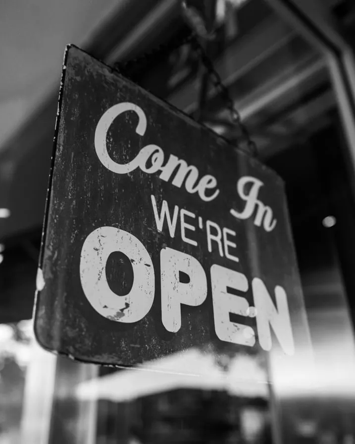 A black-and-white “Come in, we’re open” sign