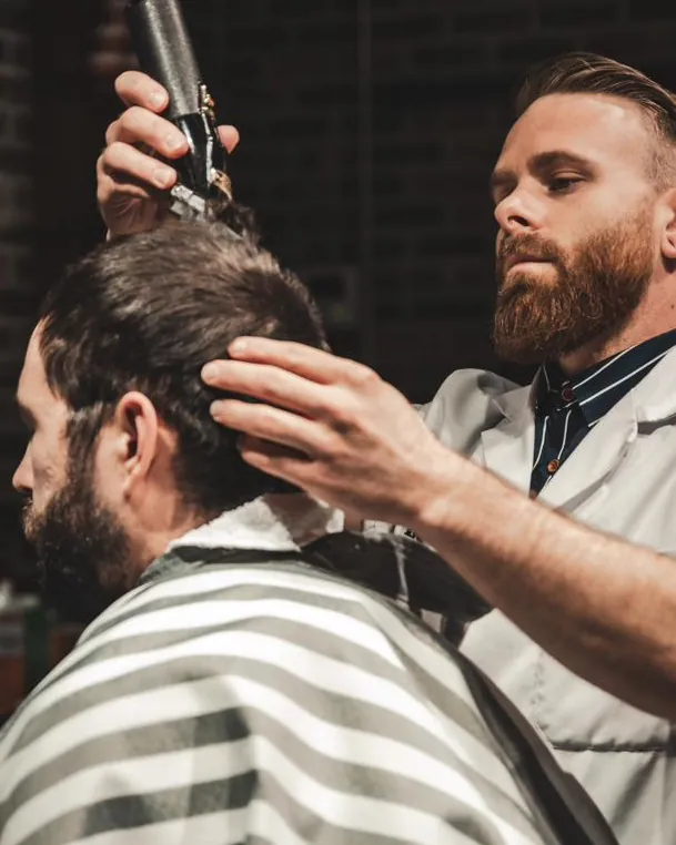 A barber combing through a client’s hair