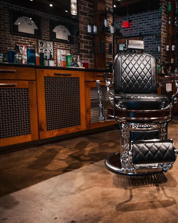 A black tufted barber chair on the shop floor
