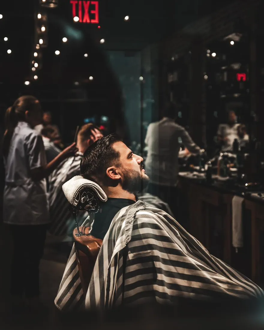 A bearded client relaxing in the barber chair during his appointment
