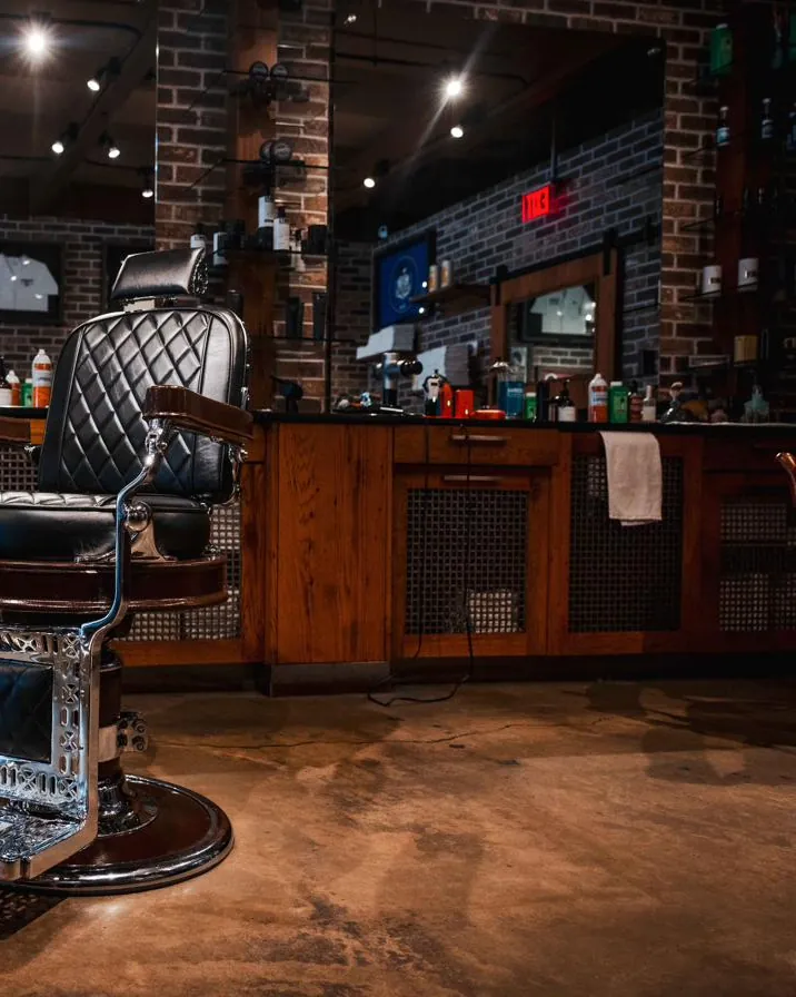 A barber chair beside the stations along the shop’s brick wall