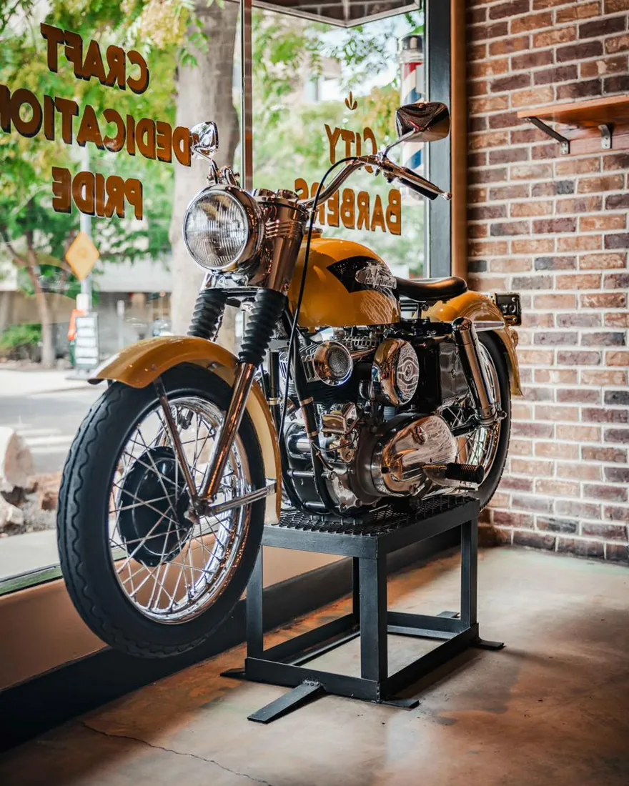 A vintage motorcycle in the City Barbers front window