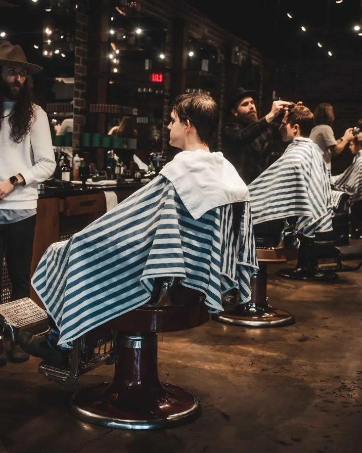 Barbers and clients along the row of chairs at City Barbers